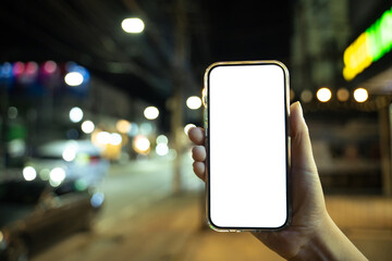 Woman hand holding empty screen of smartphone with bokeh at night time
