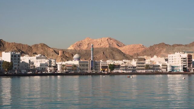 View of Mutrah Corniche with coastal road, buildings and rocky hills