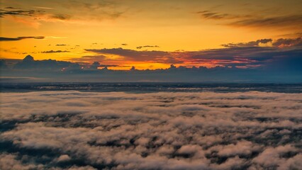 A high-altitude aerial photograph capturing a sunrise above a vast forest with golden morning mist drifting through the treetops