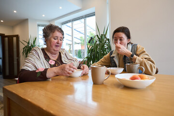Two women enjoying breakfast together in a cozy home setting