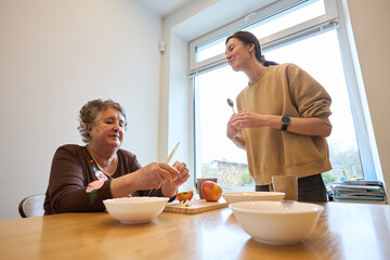 Family moment: women sharing conversation and meal preparation by the window