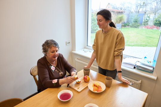 Grandmother and granddaughter enjoying a snack in a cozy kitchen setting