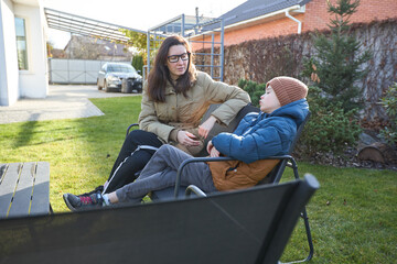 Mother and son relaxing in backyard on a sunny day
