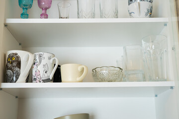 Neatly arranged kitchen shelf with mugs and glassware, giving a fresh and tidy everyday home vibe.