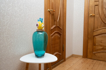 Decorative glass vase on a small table in a cozy hallway, adding color and charm to the warm interior.