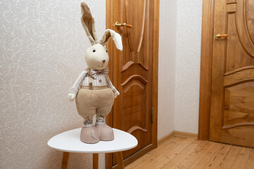 Plush rabbit toy sitting on a small table in a warm hallway, creating a charming and playful home moment.