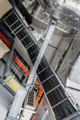 Close-up of industrial electrical installations and cable trays. Intricate network of power cables and wires for industrial or commercial infrastructure.