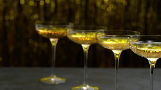 glasses of sparkling champagne on a on golden stylish background. Row of champagne glasses filled. Lot of glasses filled with champagne are lined up.
Many glasses of champagne in a line. Lots of cham