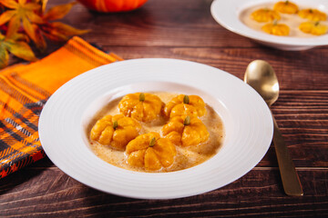Delicious Homemade Pumpkin Gnocchi in the form of pumpkin with sauce. Cozy autumn meal concept.	