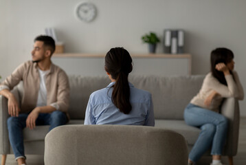Female psychologist helps an Arab couple resolve their conflict in a therapy session at a...