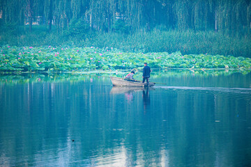 Tangshan City, Hebei Province, China - July 11, 2024: A fisherman drives a small fishing boat to...