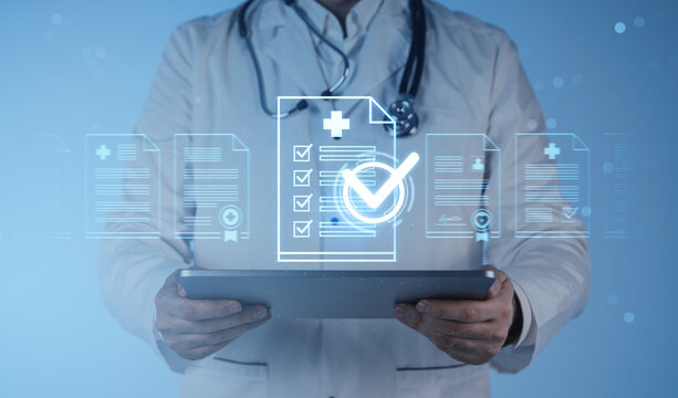 Doctor using tablet with digital medical records and checklist icons on futuristic blue background representing healthcare data management concept.
