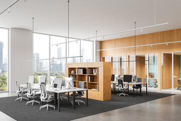 Modern open space office interior with shared desks, ergonomic chairs, glass partitions, and cityscape view through large windows. 3D Rendering