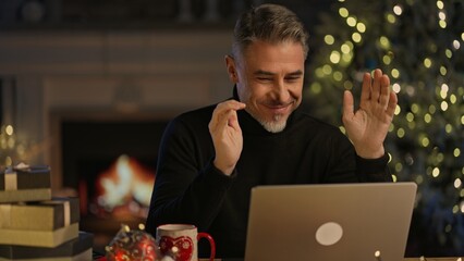 Virtual Christmas online - Happy smiling middle aged man hat at home video chatting with family on...