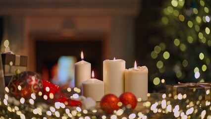 Still life of Christmas decoration and candle at home in cosy living room with fireplace. Winter holiday mood.