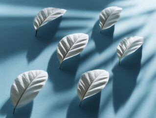 Close up pattern of white leaves across light blue surface