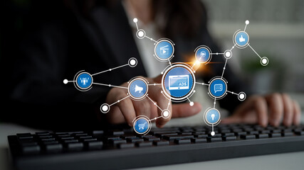 A business professional interacts with a keyboard while surrounded by digital marketing icons, showcasing the integration of technology in modern advertising strategies. Tessel