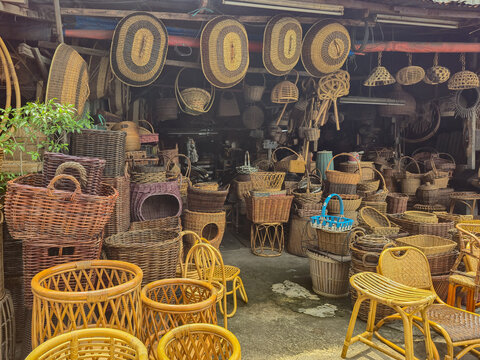 ​Traditional rattan and bamboo handicraft shop. Collection of handmade woven wicker baskets, furniture, and natural home decor display.