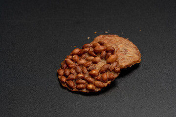 Fried peanut cookies on black background, Beans over rice crispy plate, Thai food.
