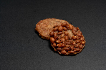Fried peanut cookies on black background, Beans over rice crispy plate, Thai food.