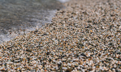 close-up of ocean waves crashing onto a pebble beach