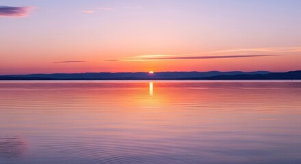 Obraz premium Vibrant Sunset Glow Over Calm Water with Orange and Pink Sky Reflection