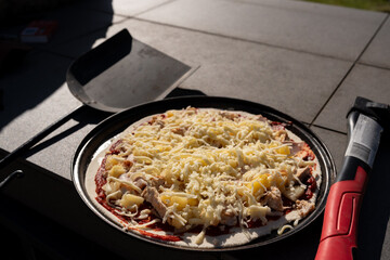 pizza in a pan ready to go in oven outdoors