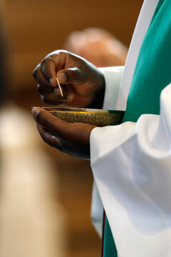 Saint Agatha Church. Catholic mass. African priest giving communion. Rumilly. France.