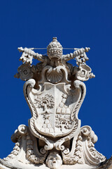 St. Peter&rsquo;s Basilica. Papal coat of arms with crossed keys and tiara carved in stone above Vatican entrance.