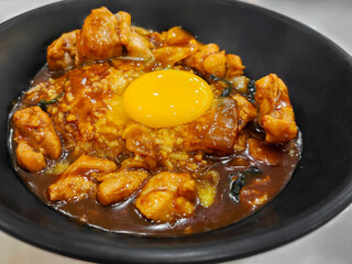 Tender chicken coated in barbecue sauce, served with steamed rice and topped with an egg.