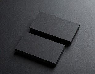 Minimalist mockup of two blank black business cards on a dark textured background for branding.