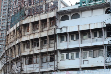 Dilapidated building exterior with scaffolding, showing signs of age and decay