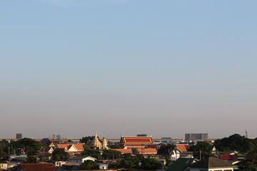 Scenic view of traditional Thai temples and buildings under a clear blue sky