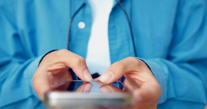Close-up of female hands using mobile phone outdoors, typing and messaging in online chat. Communication and technology concept. - Powered by Adobe