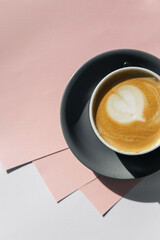 Latte art in a glass on a pinkish-gray background