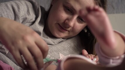 Authentic close up shot of young neo mother is playing with her newborn baby in a nursery in a morning. Shot in 8K. Concept of children,baby, parenthood, childhood, life, maternity, motherhood