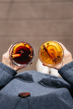 White and red mulled wine in glasses is held in a girl's hands, top view. Copy space for inscription