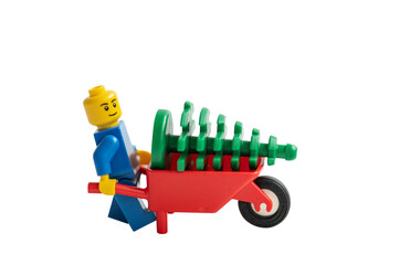 Obraz premium Lego man pushing a wheelbarrow isolated on white background.