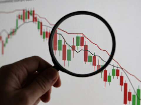 Analyzing downward stock market trends with magnifying glass, financial investments, economic crisis, and portfolio risk management for modern business solutions