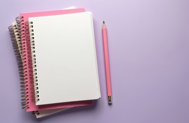Stack of pink and white spiral notebooks with open blank pages. Single pink pencil rests beside them on pastel purple surface. Top view of stationery for writing notes or drawing.