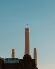Industrial power station chimney spewing thick smoke into the blue sky, symbolizing pollution from coal and gas energy production