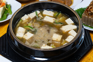 hot doenjang jjigye in a black ceramic bowl. A Korean cuisine