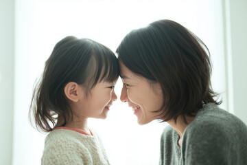 優しい光の中で額を寄せ合う母娘の微笑ましいひととき