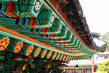 colorful wooden eaves and a hanging electric lamp at the Buddhist temple building