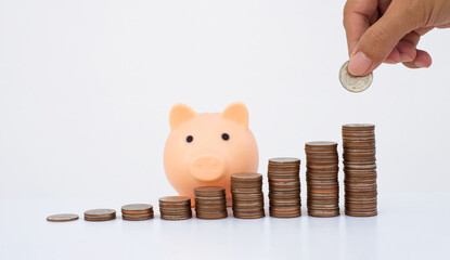 money saving concept. business man han dropped coin on piggy bank with coin stack on white background. money matters tips to investment and business financial banking for Financial Wellness.