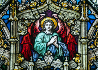 Fototapeta premium Stained glass (19th century) of an angel in adoration and prayer.