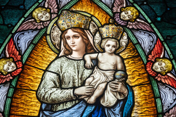 Obraz premium Stained glass (19th century) of Blessed Virgin Mary holding baby Jesus Christ in her arms.