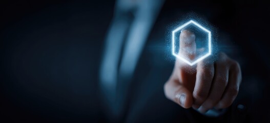 A person in a suit uses a glowing hexagon interface, emphasizing technology and interaction