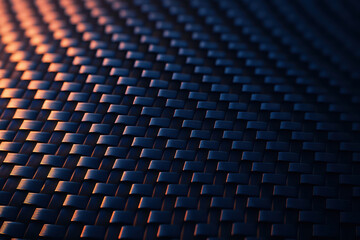 Obraz premium Carbon fiber weave texture with dark blue and orange lighting, close up of woven pattern surface showing detailed fiber structure and reflective material