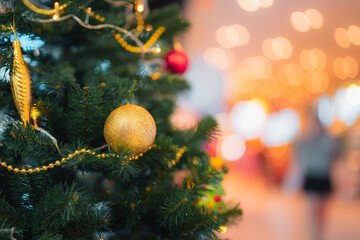 Close up Christmas tree decoration.Golden ornament ball,red sphere,lights hang pine needle.Festive holiday background,celebrate December season. Bokeh effect magic,warm,cozy atmosphere with copy space